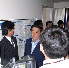 沈痛な面持ちで党本部会見場に入る安倍首相