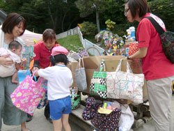 好きな柄のトートバッグを選ぶ子どもたち。右は難民を助ける会の高橋智美