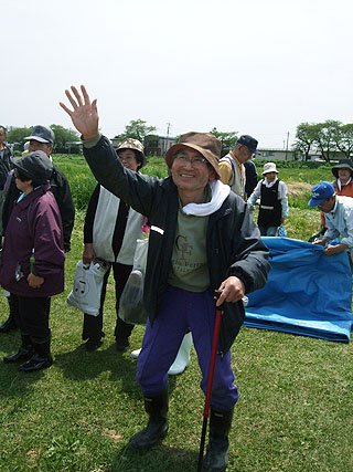 園児たちの激励に手を振って感謝する被災者の老人