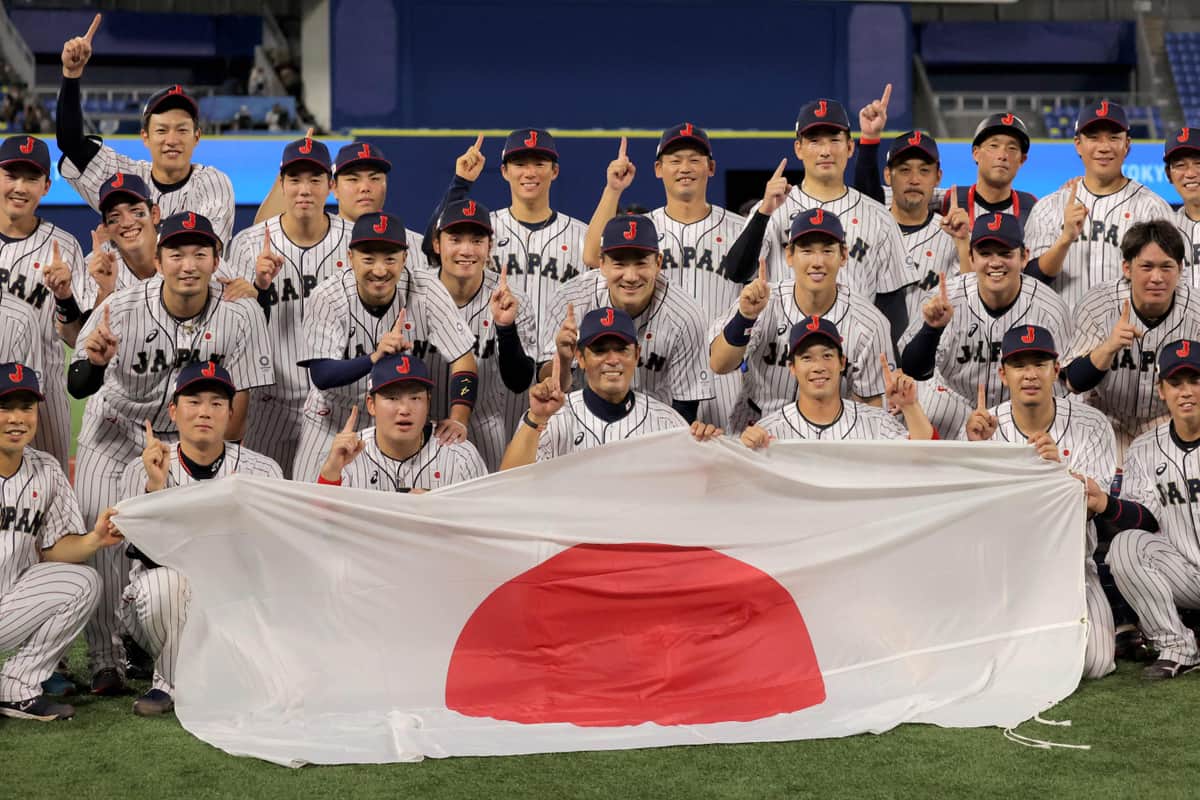 東京五輪で優勝した侍ジャパン。前列左から3人目の村上宗隆選手の頭上に、菊池涼介選手の人差し指がある（写真：AFP/アフロ）