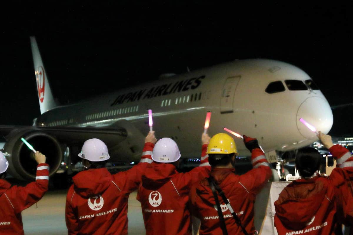 ホノルル行きのJL74便をペンライトで見送る日本航空（JAL）スタッフ。ちょうど70年前JALは国際線路線を開設した