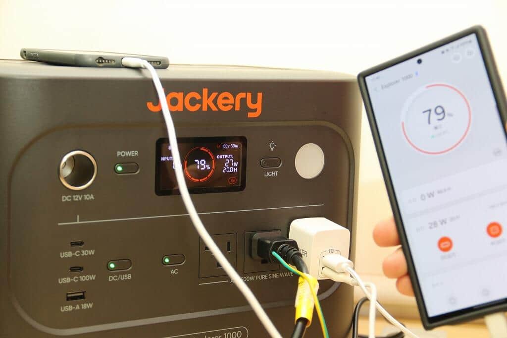 「Jackery ポータブル電源 1000 New」でスマホを充電。スマートフォンのJackery専用アプリと本体を接続すると、バッテリー残量や残り時間の確認、電源出力やライトのオン／オフを遠隔操作できる