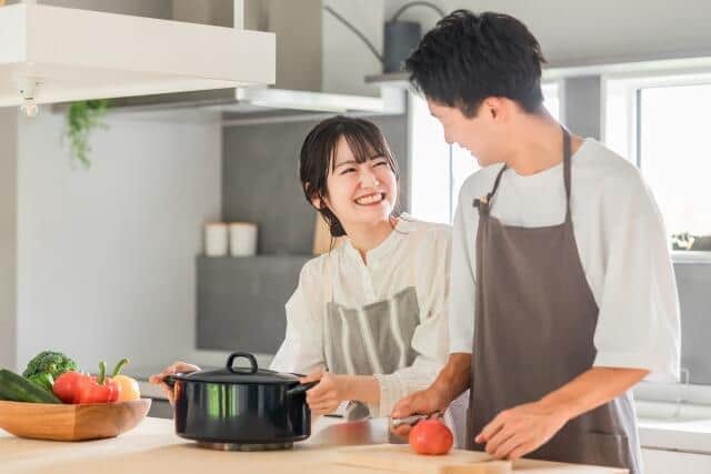 一緒に料理を作る若い夫婦（写真はイメージ）
