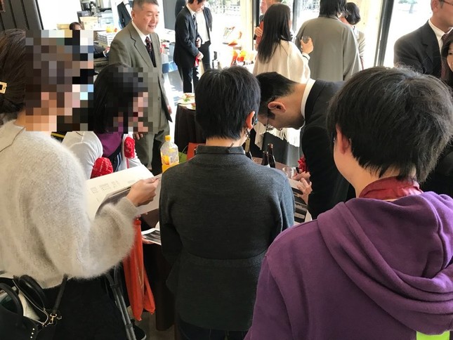 刀鍛冶が女性にサインをしている光景（写真は木下宗風さん提供）