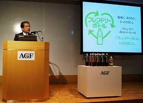 2011年11月21日、都内で記者会見を行う村林誠社長。表示されているのはフレンドリーボトルのロゴマーク